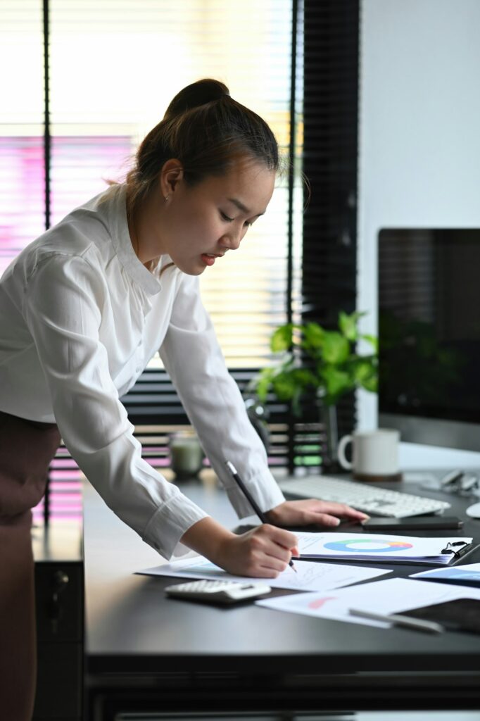 Female accountant or banker calculating tax and salary at office desk.